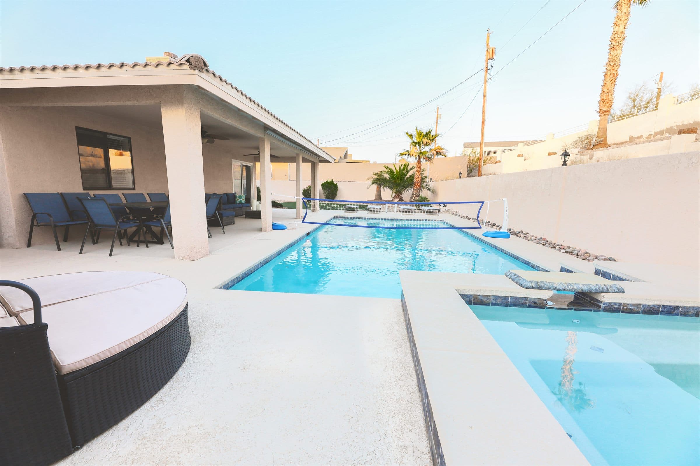 Heated backyard pool with lounge chairs and desert light